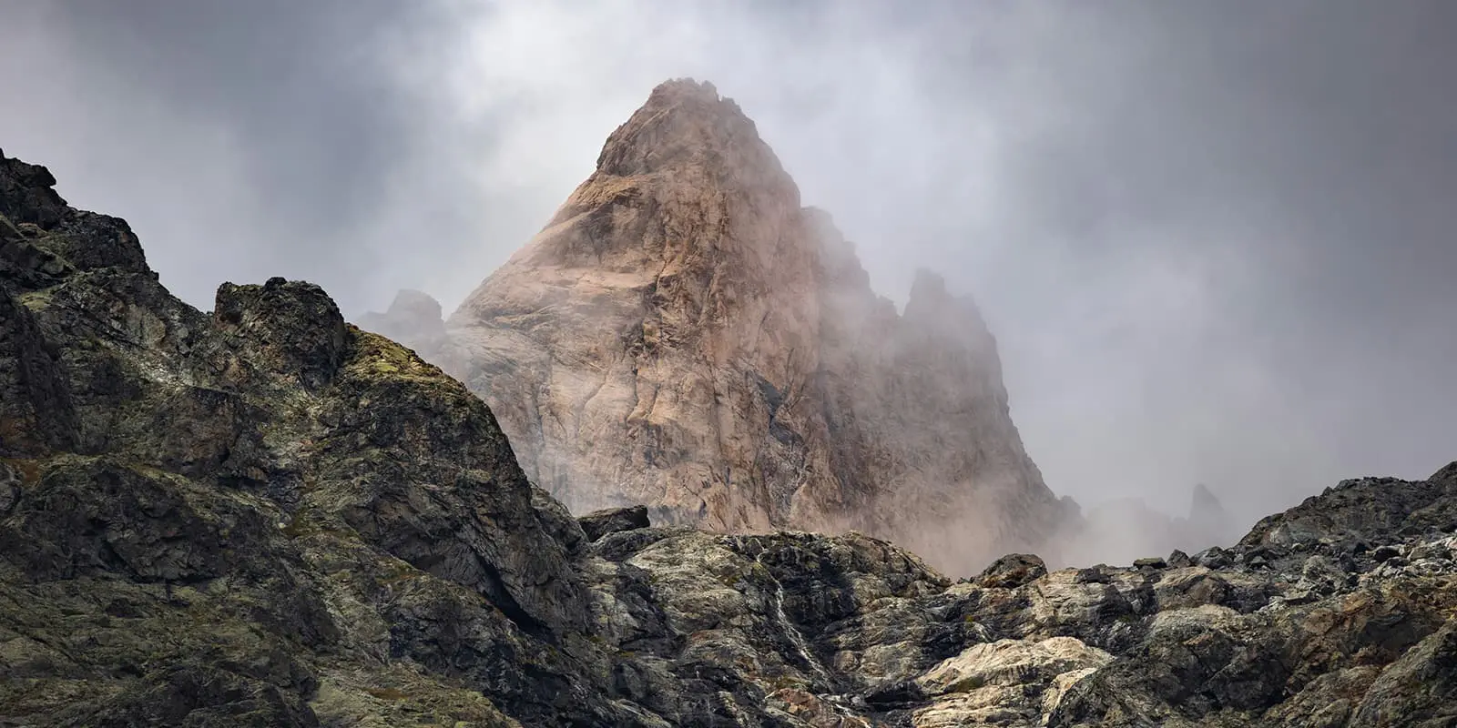 mountain towering above clouds in Ecrins national park