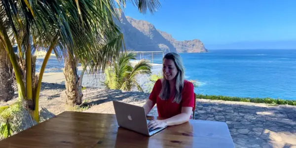 person working on laptop near the beach