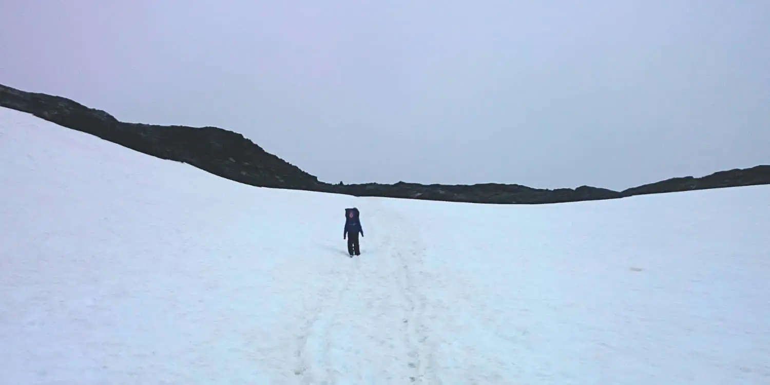 person hiking in the snow on cloudy day