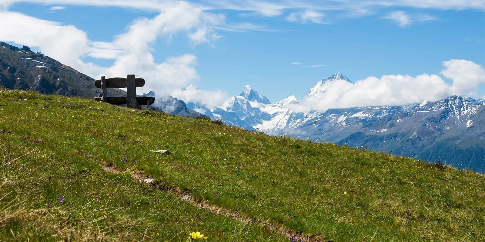 wooden bench overlooking the swiss mountains near the Illhorn mountain top