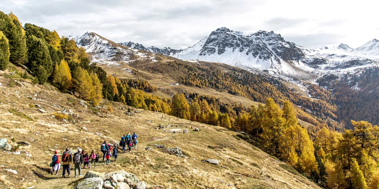 big group of people hiking in the Swiss mountains during fall time