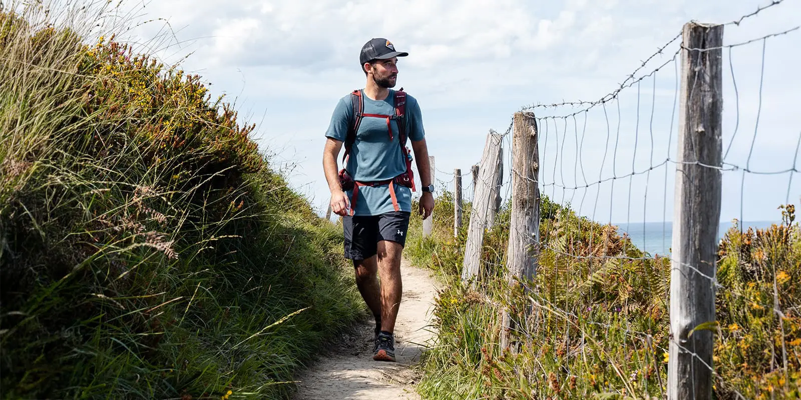 man hiking on narrow trail wearing a merino shirt from Pinewood