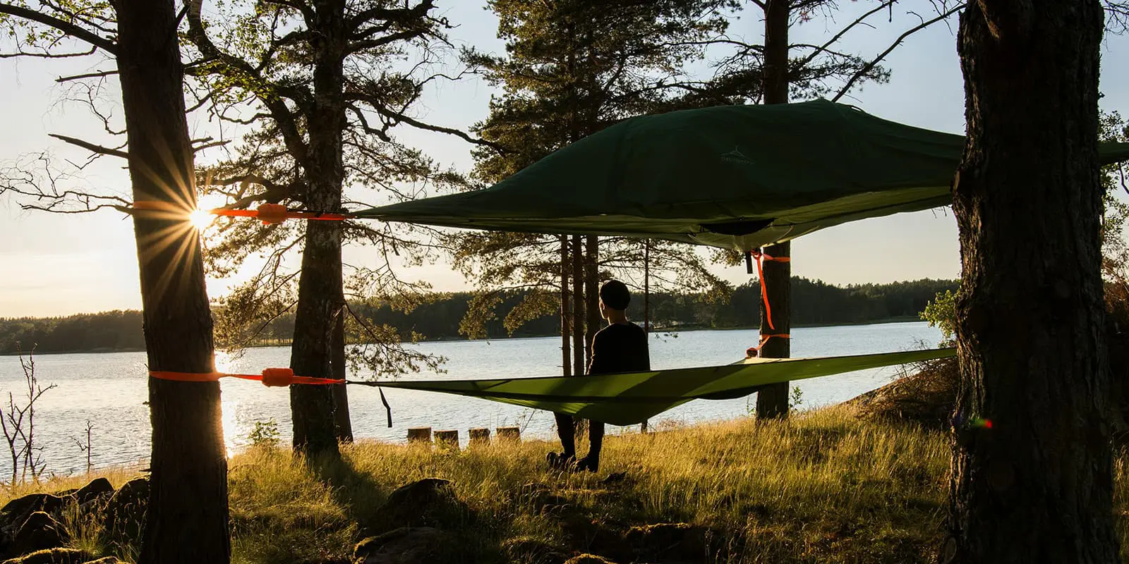 person in hammock overlooking a lake