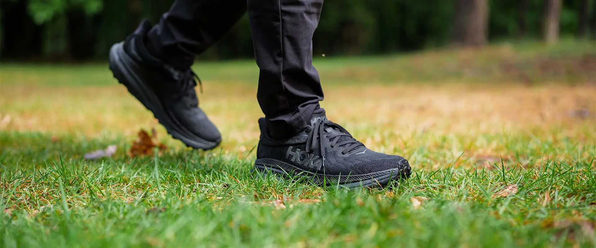 close-up of person hiking on grassy surface
