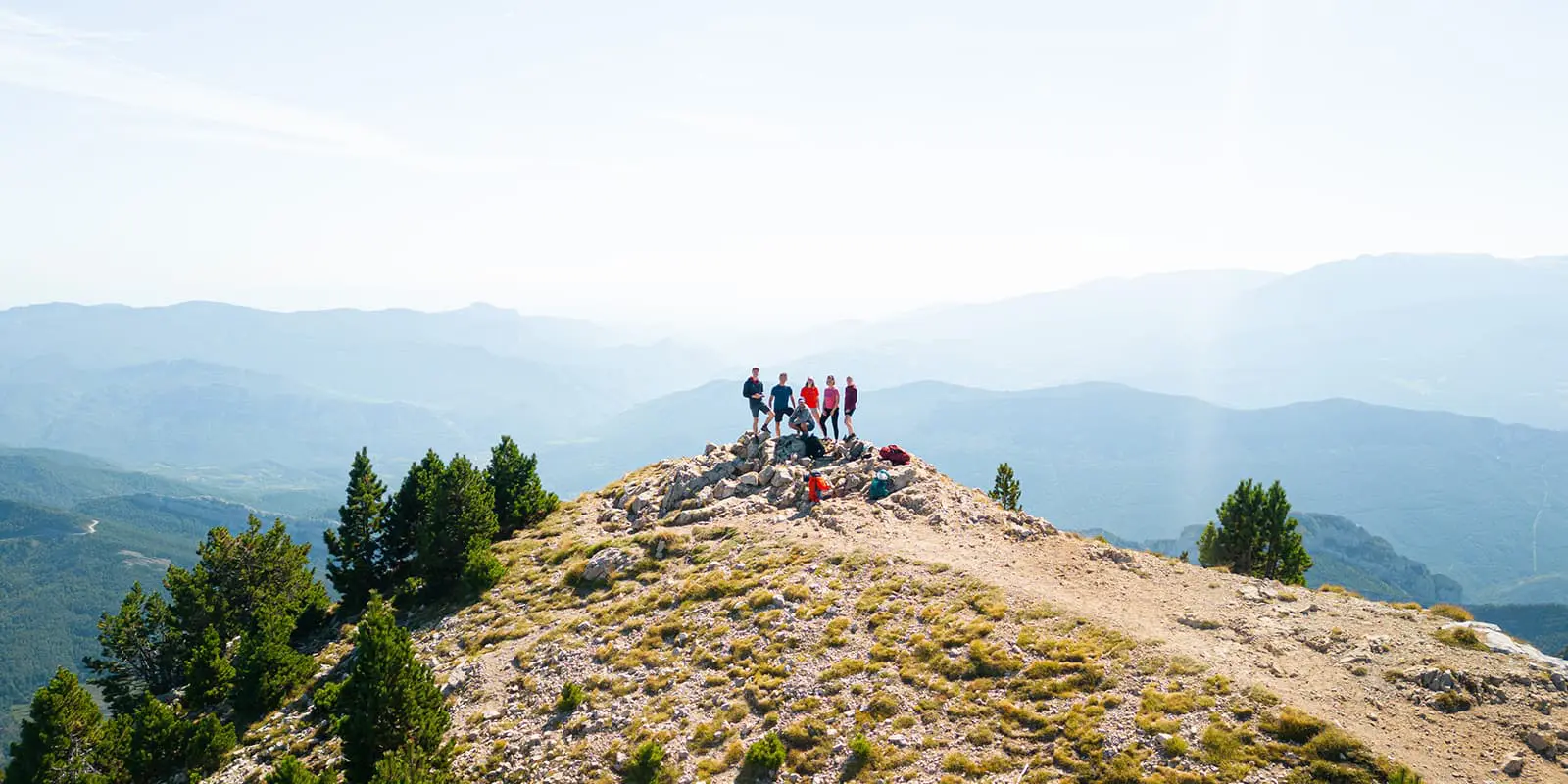 group of hikers posing on top of a mountain in the Catalan Pyrenees