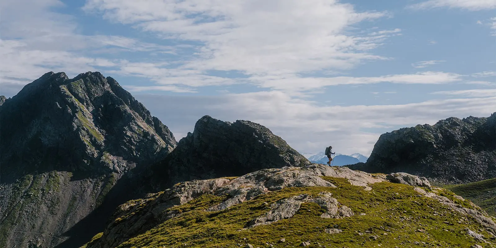 person hiking on the Hufeisentour with rugged peaks behind her