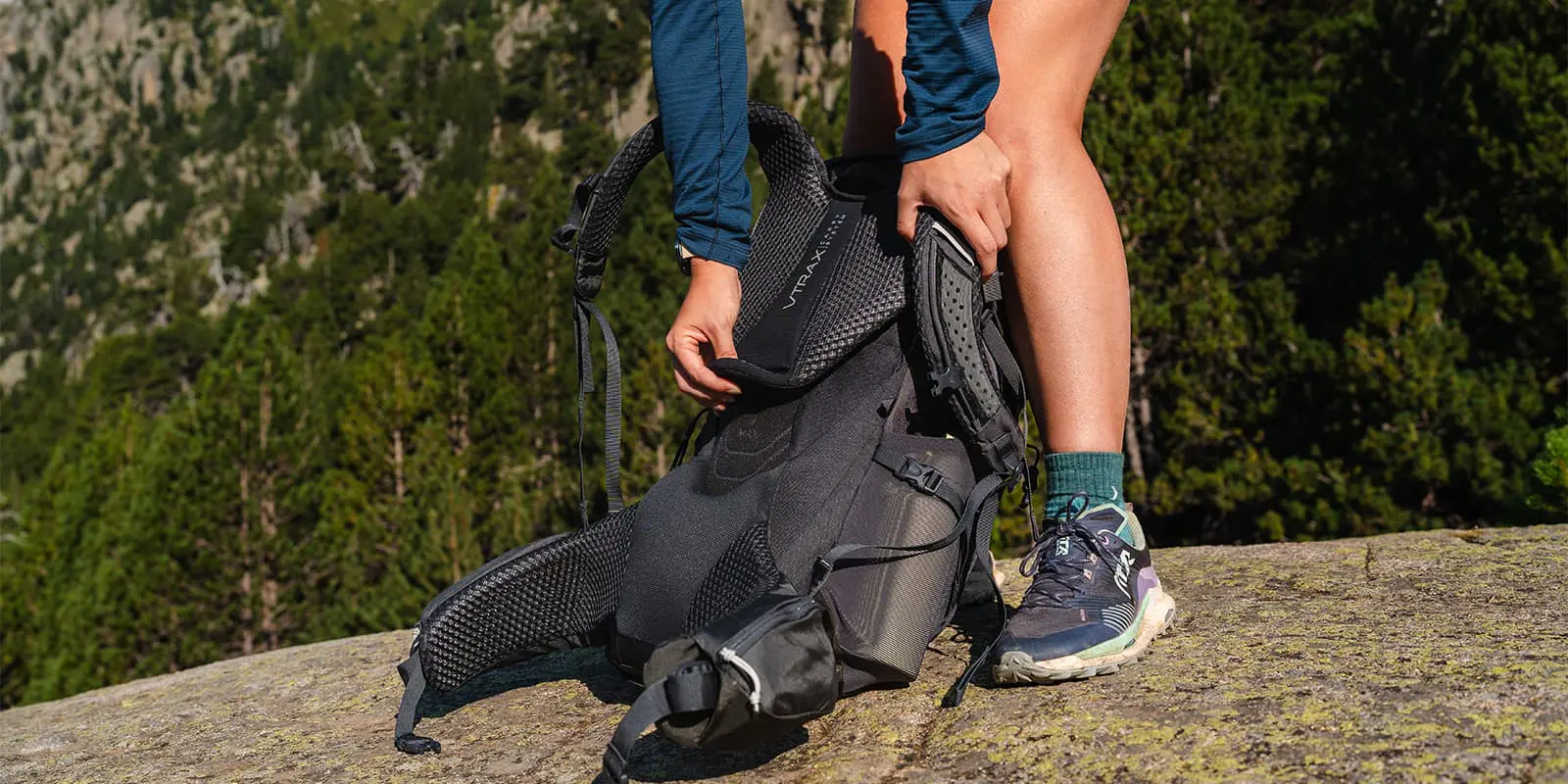 person adjusting back length of her RAB backpack