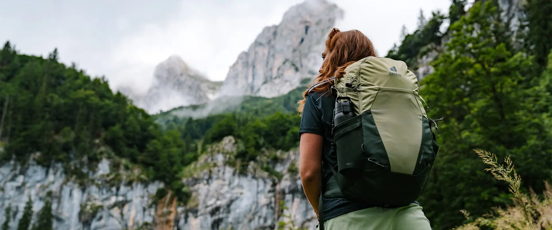 person wearing Deuter Futura 23 backpack looking up to mountain top in the Austrian Alps