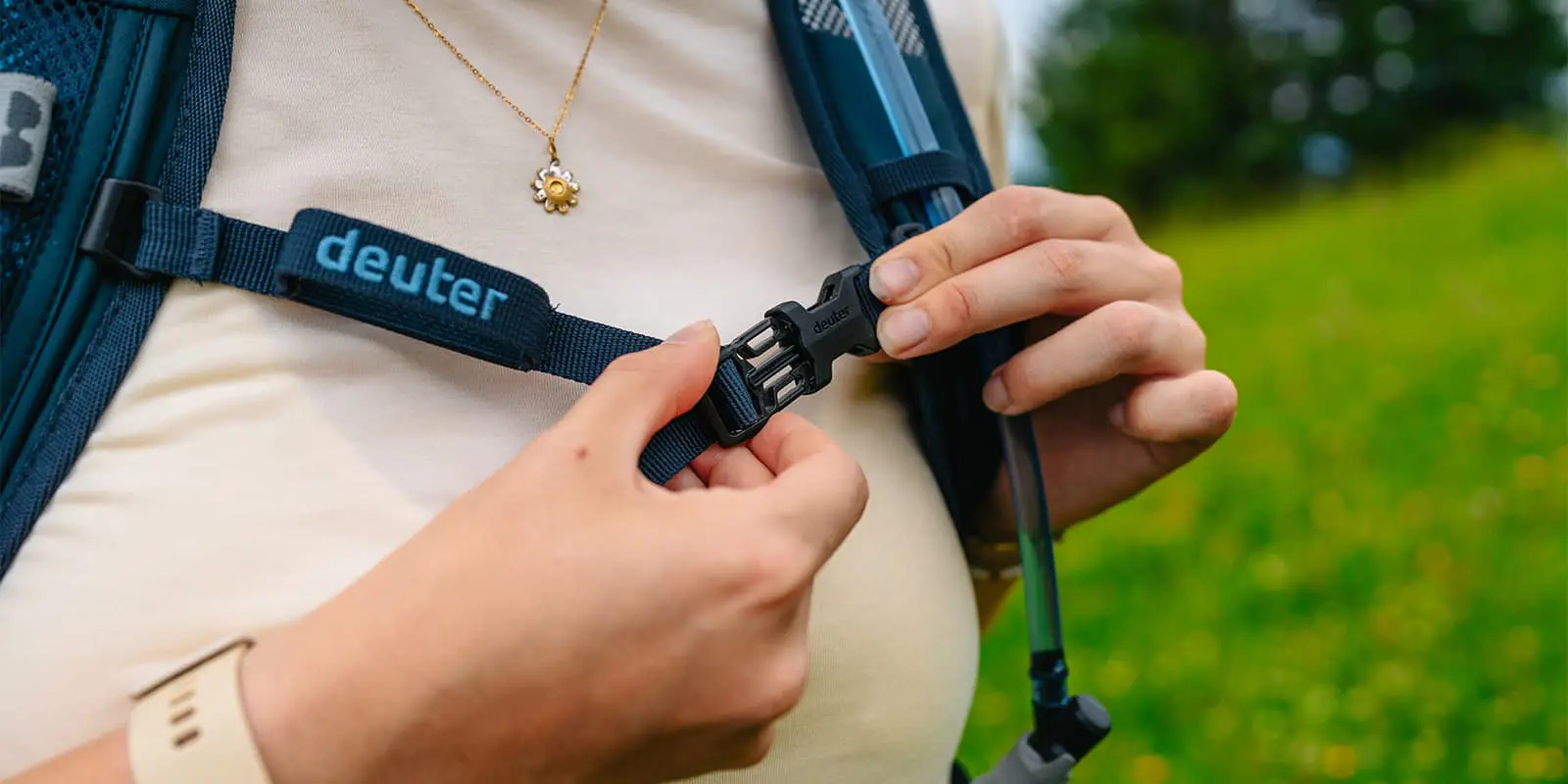 person clicking in the chest strap on a Deuter backpack