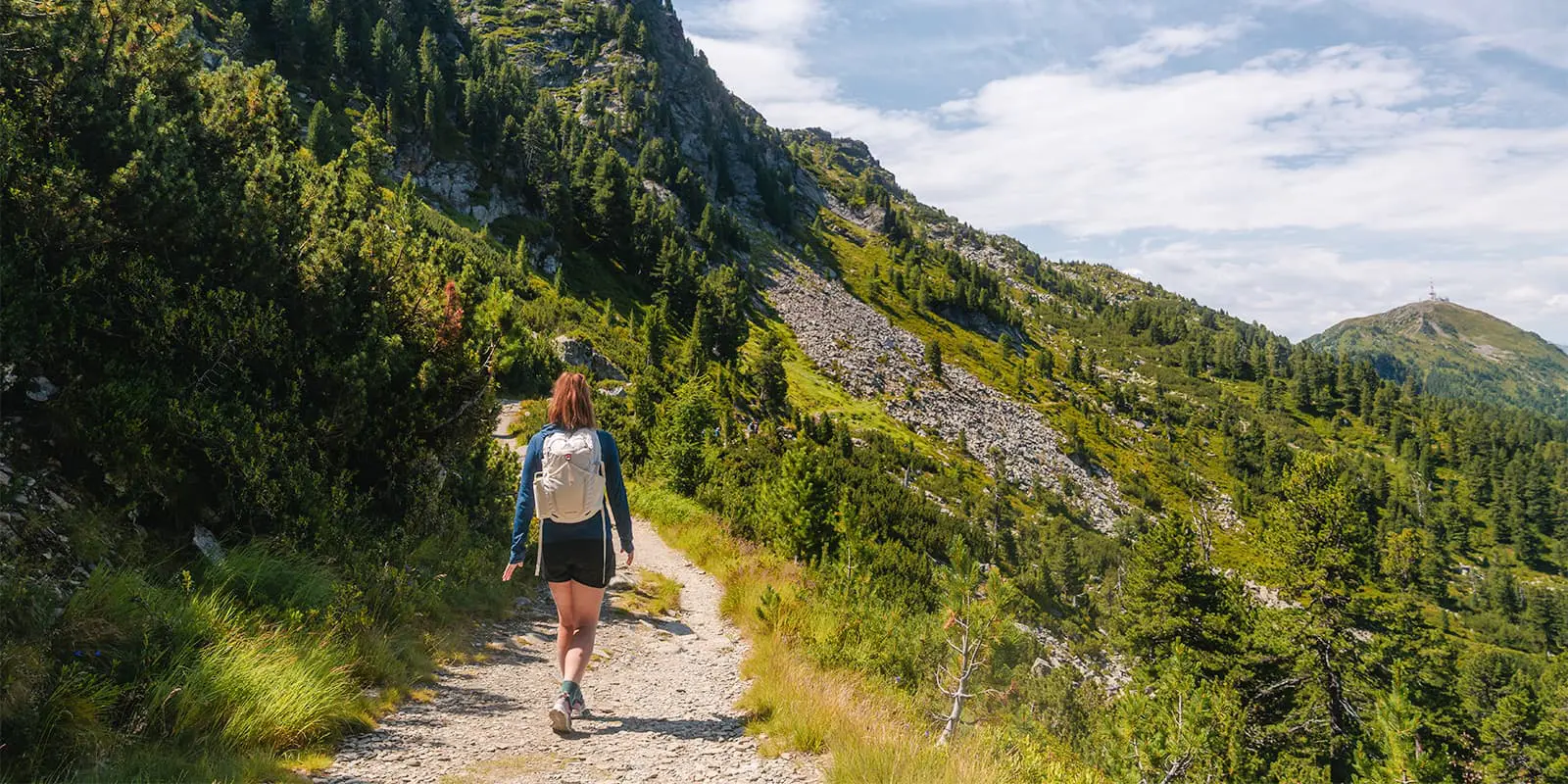 person hiking on the Zirbenweg overlooking the city of Innsbruck