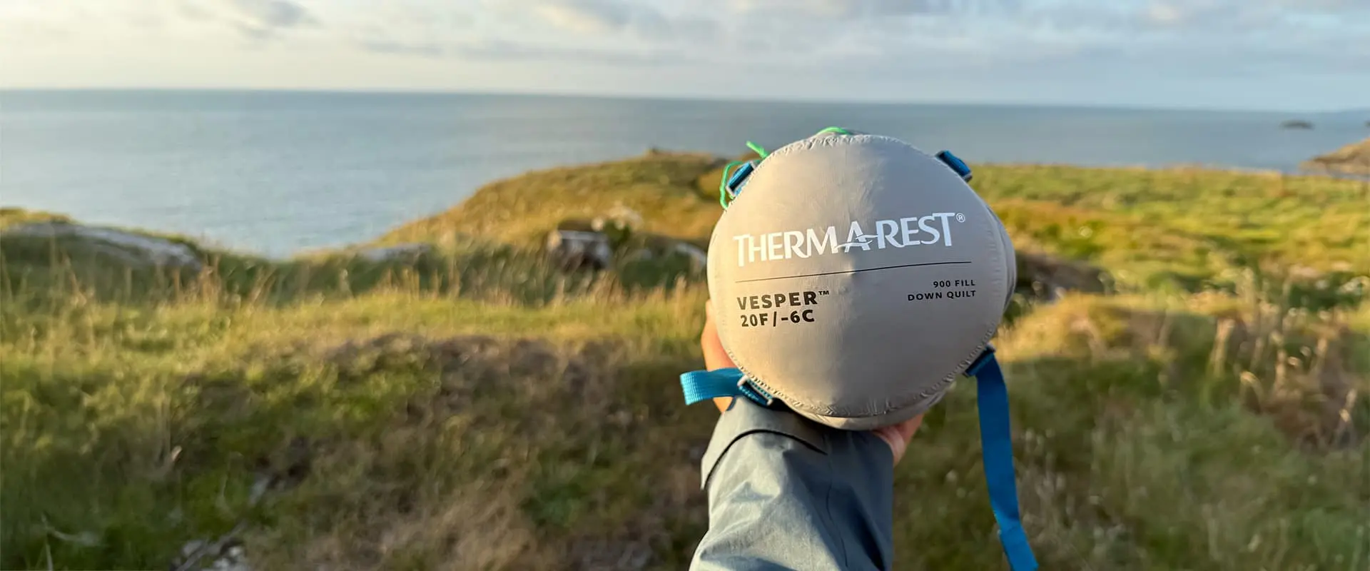 person holding a packed sleeping bag from Thermarest