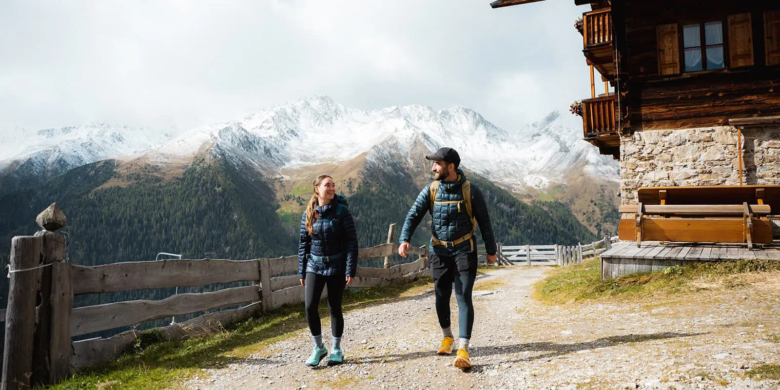 hikers on the Almweg 2000 with snow capped mountains in the background