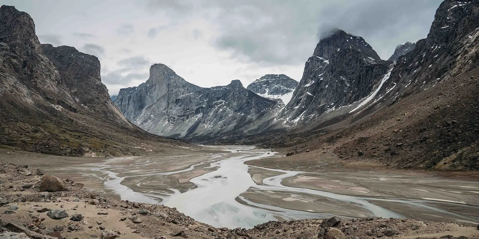 Granite walls lean over a valley on the Akshayuk pass hiking trail
