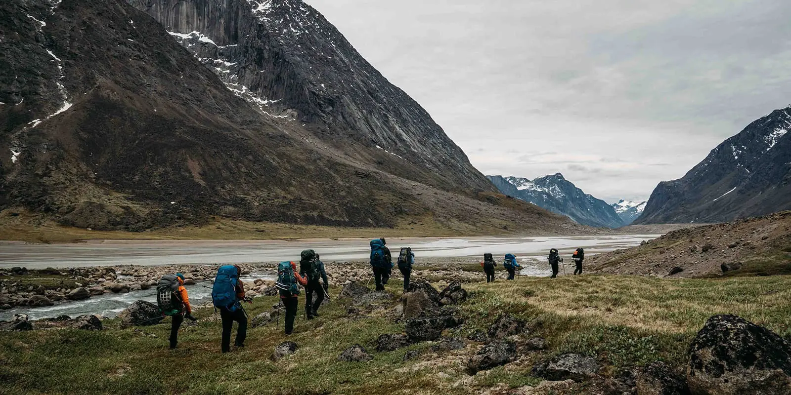 group of hikers in mountain valley on the Akshayuk pass hiking trail