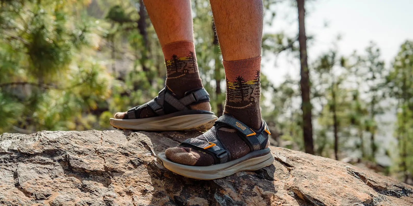person standing on rock wearing the Teva Aventrail R2T Sandal