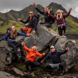 The hiking community smiling on a rock.
