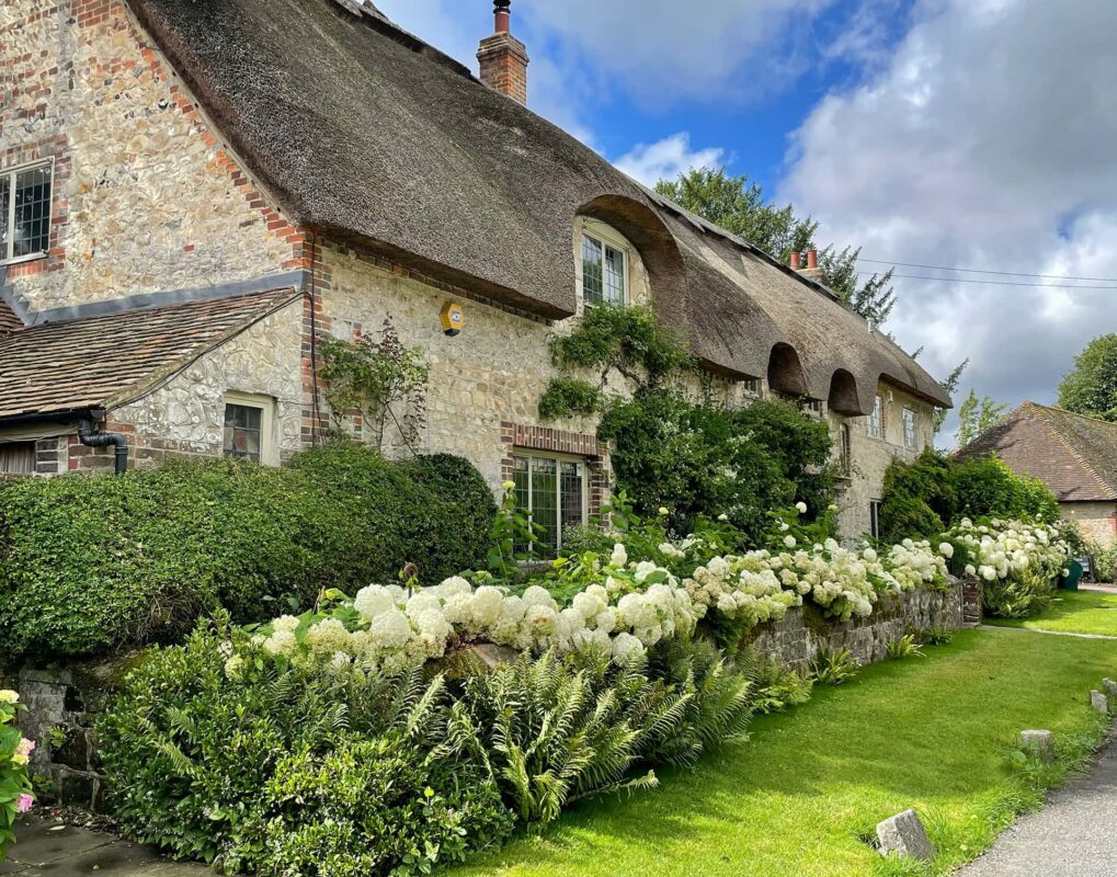 Typical English cottage, brown and white with green garden