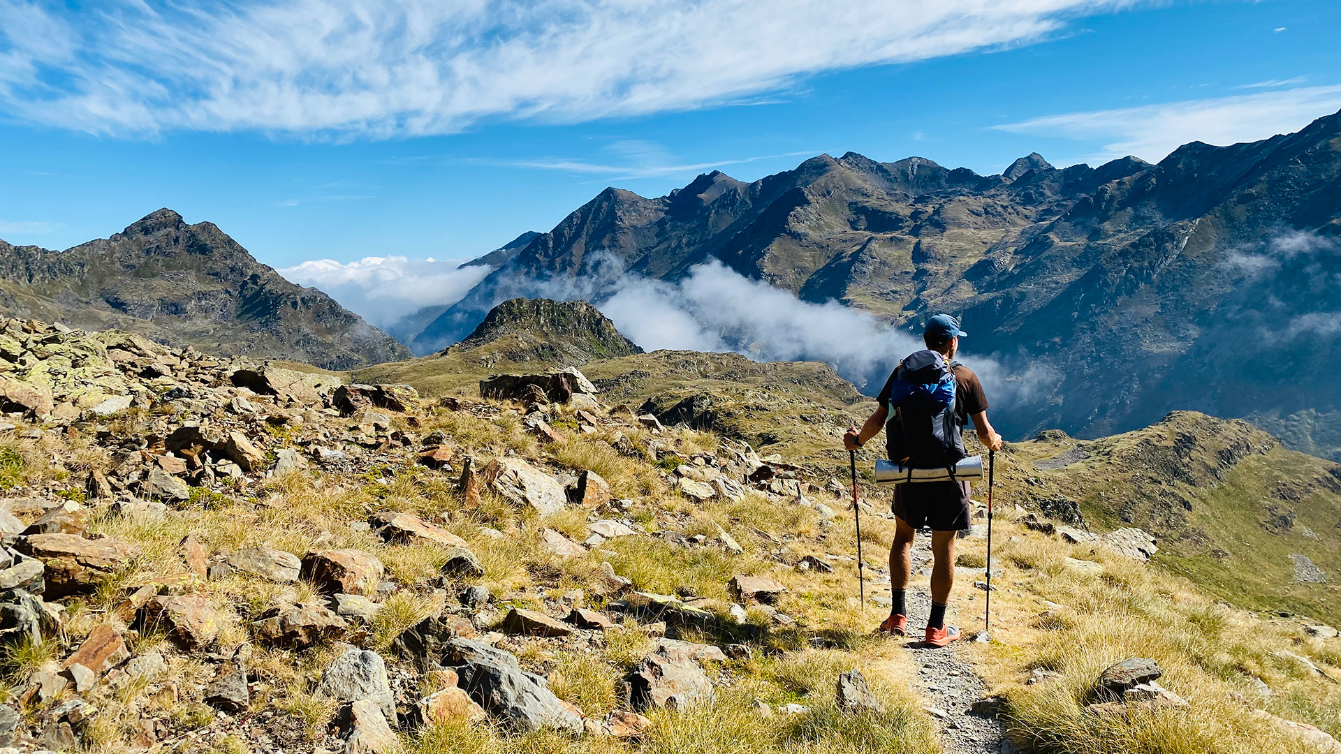Man hiking the Haute Route Pyrenees, looking out over the mountains