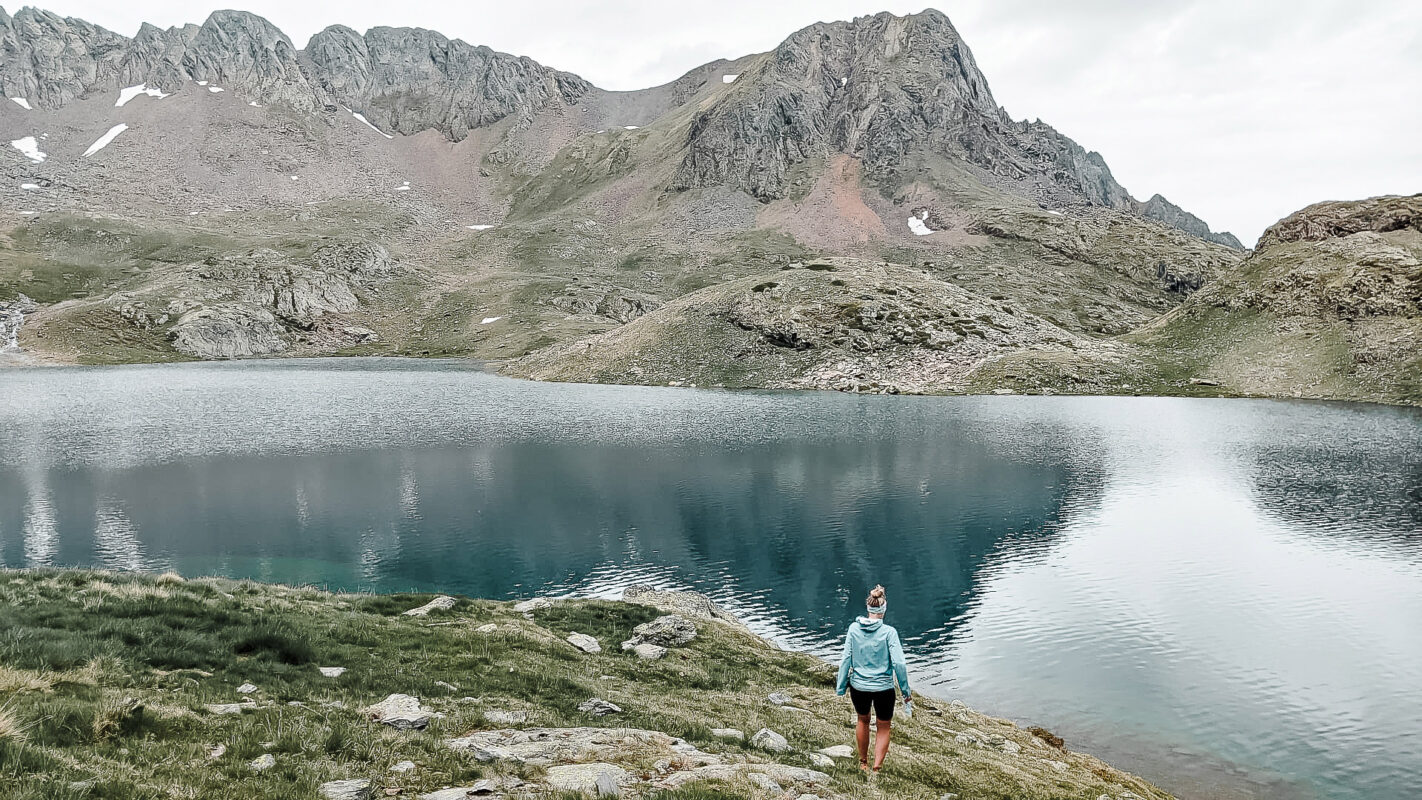 Women looking over a lake in the Pyrenees on a cloudy day