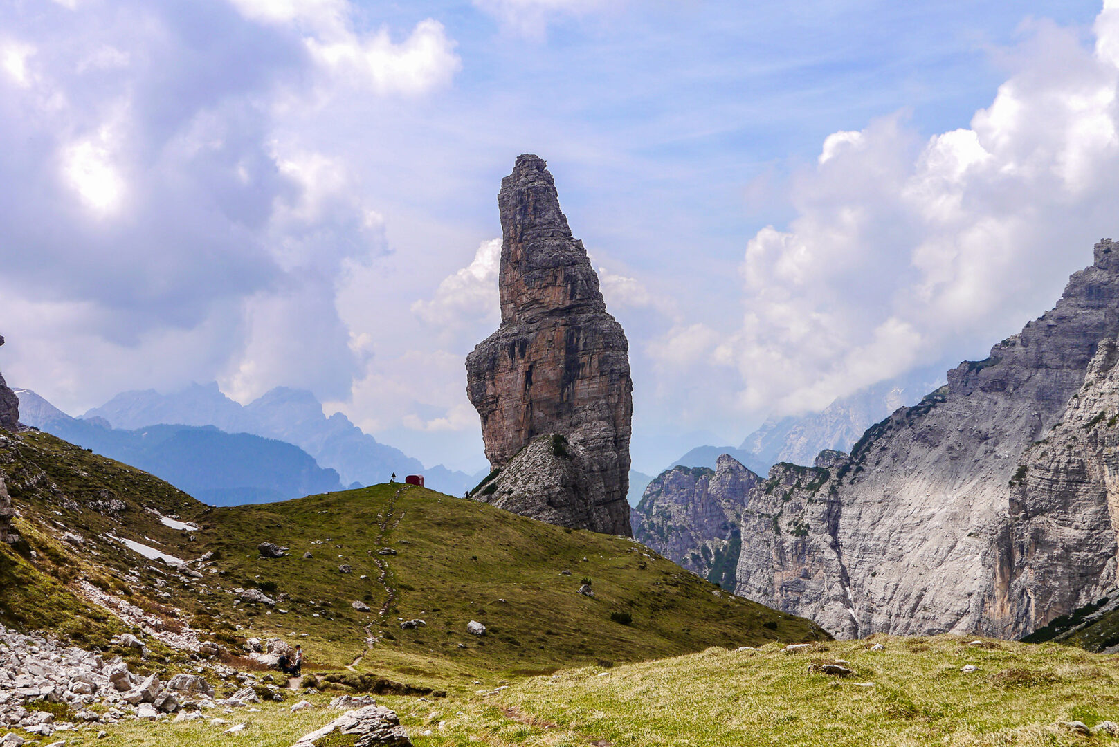Mountain path leading to shelter with rocks towering beside in Dolomites Italy