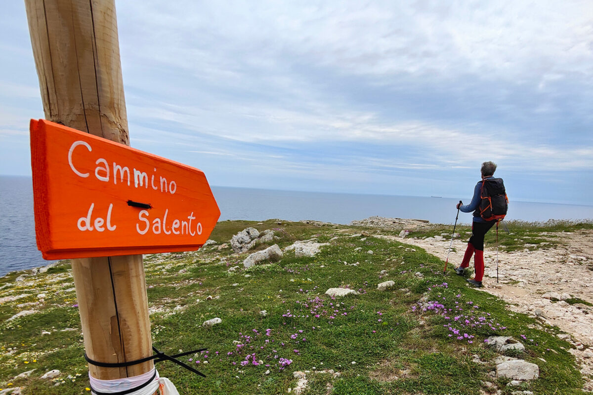 Cammino del Salento way sign, hiker in the background