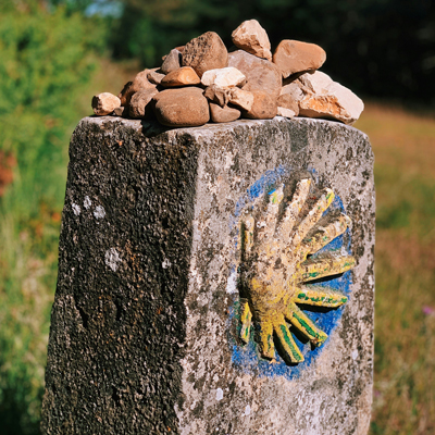 Stone with the logo of the Camino de Santiago on it.
