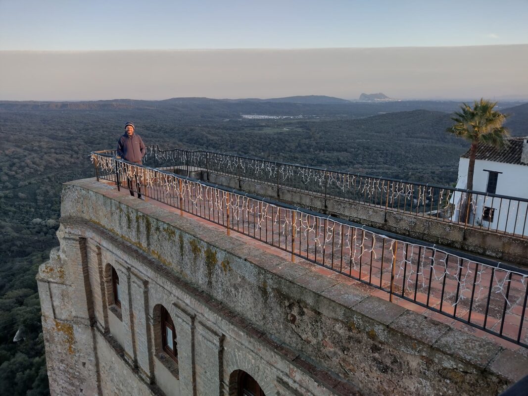 Man on rooftop terras looking out over green landscape