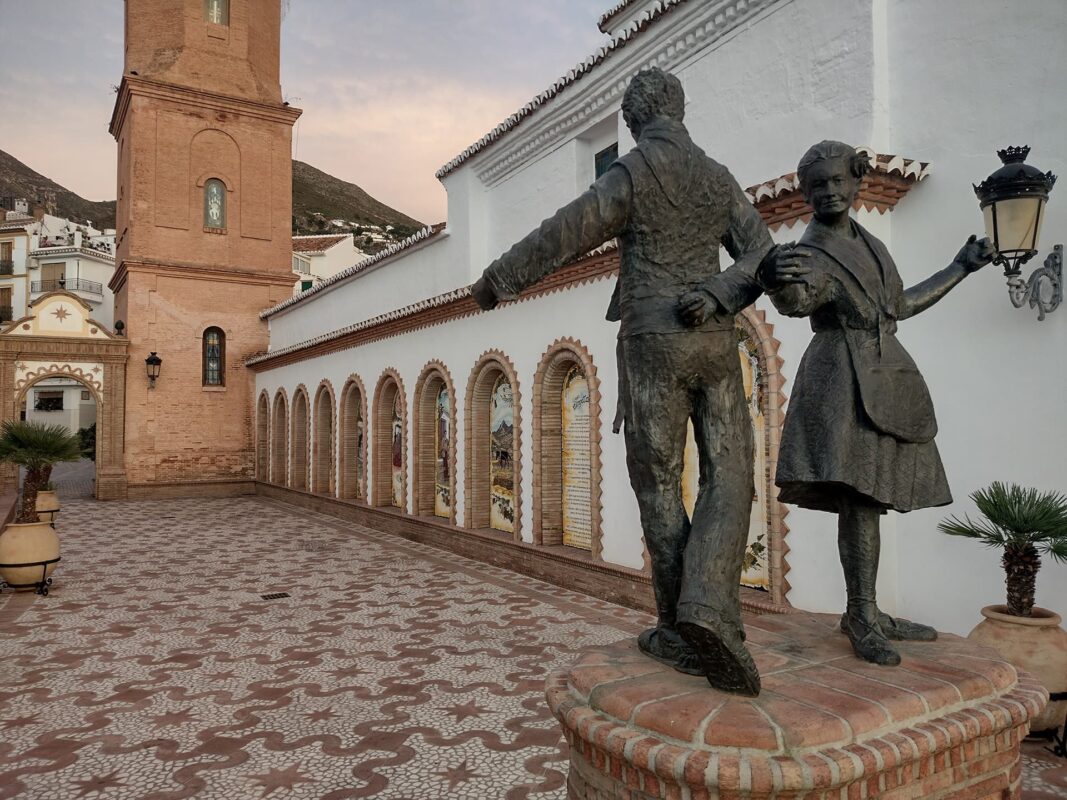 statue of a man and women dancing in the middle of Spanish square