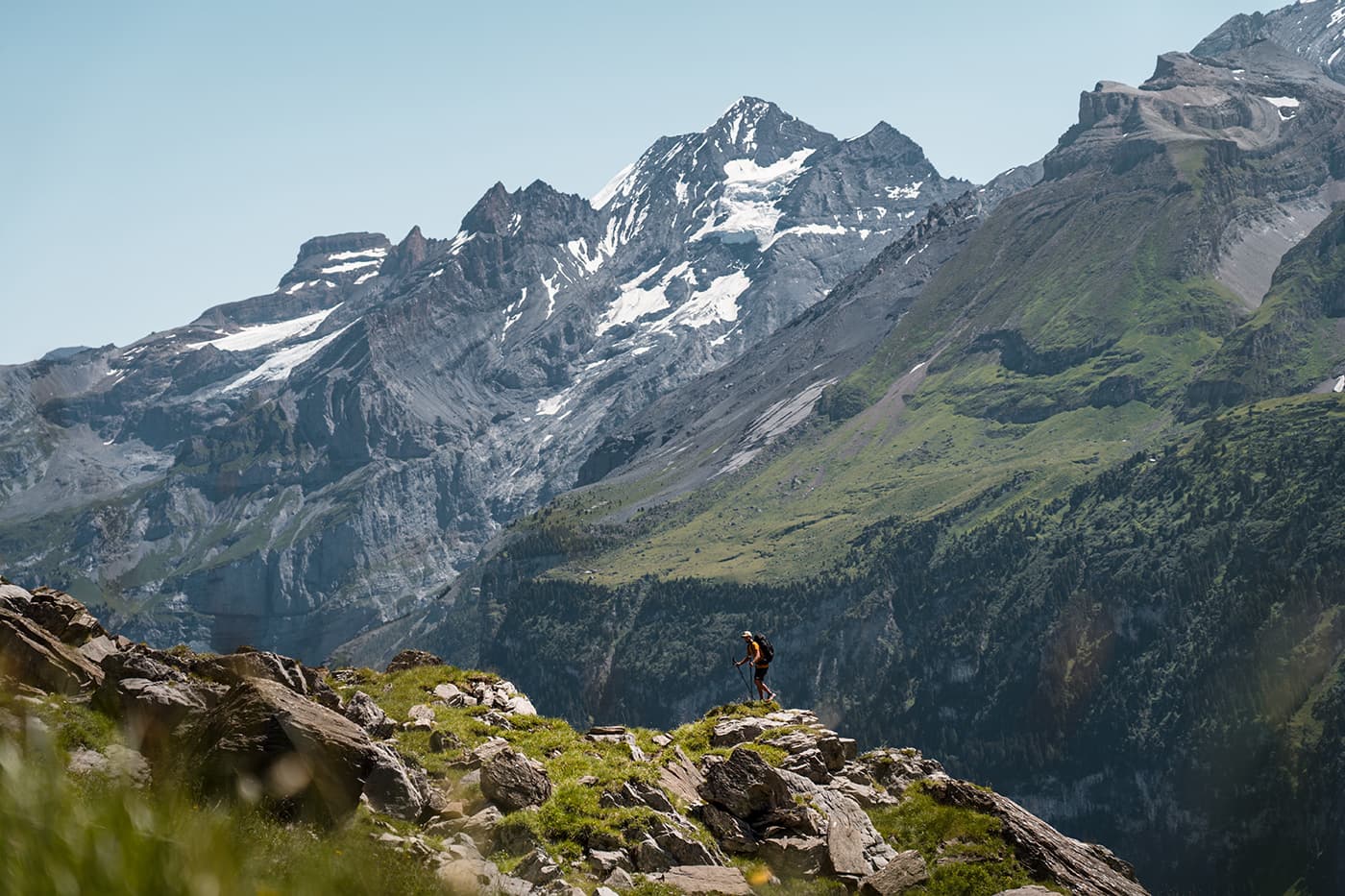 man hiking on rocky surface with mountains in background