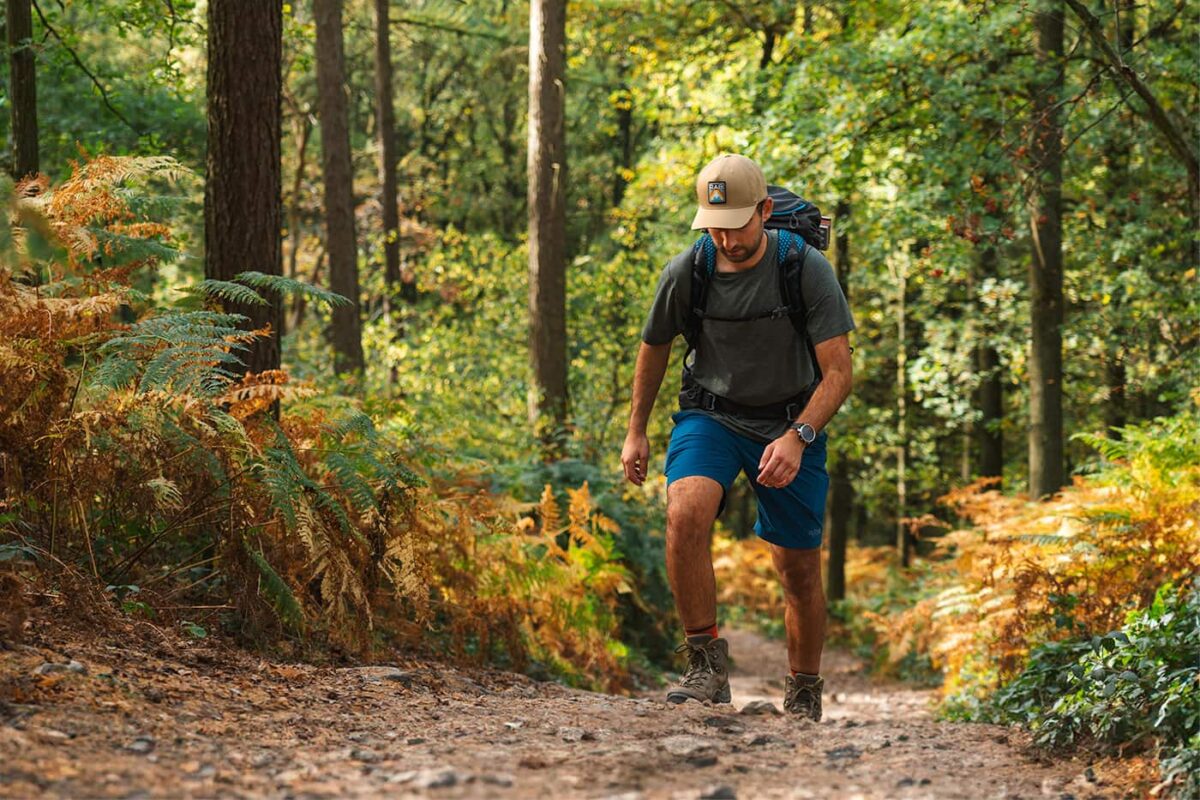 man hiking through forest on unpaved path