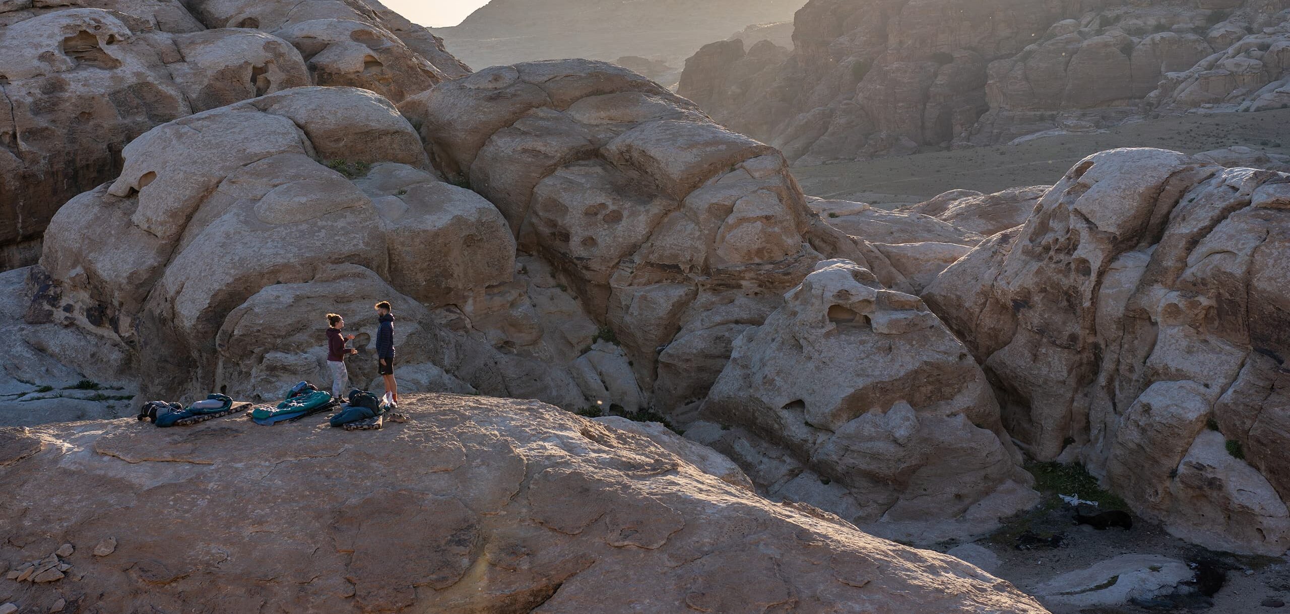 Two persons standing on rocky surface in desert