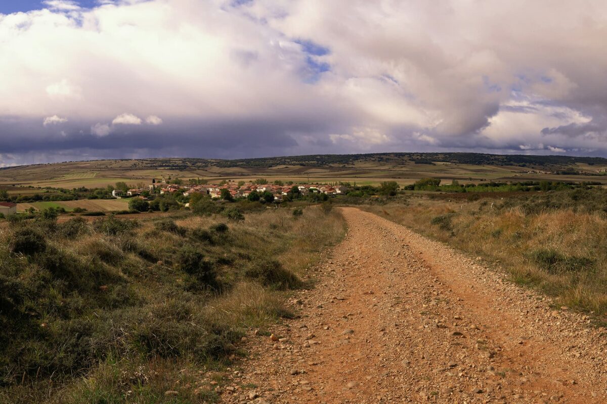 gravel road leading up to small town in Spanish countryside