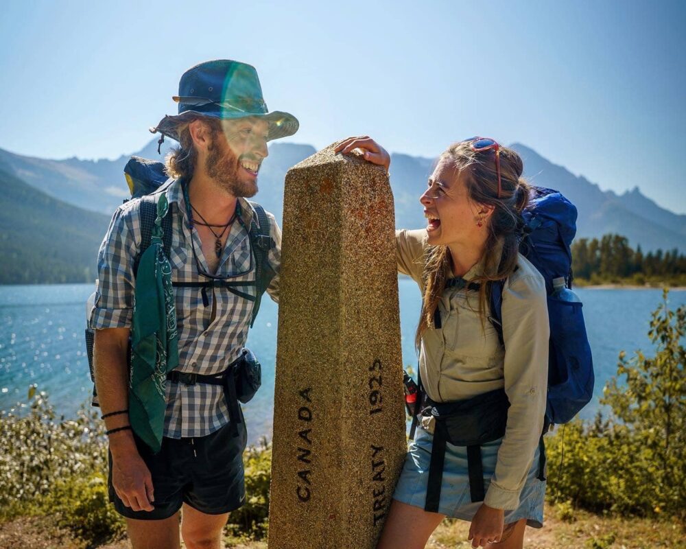 man and women laughing near body of water