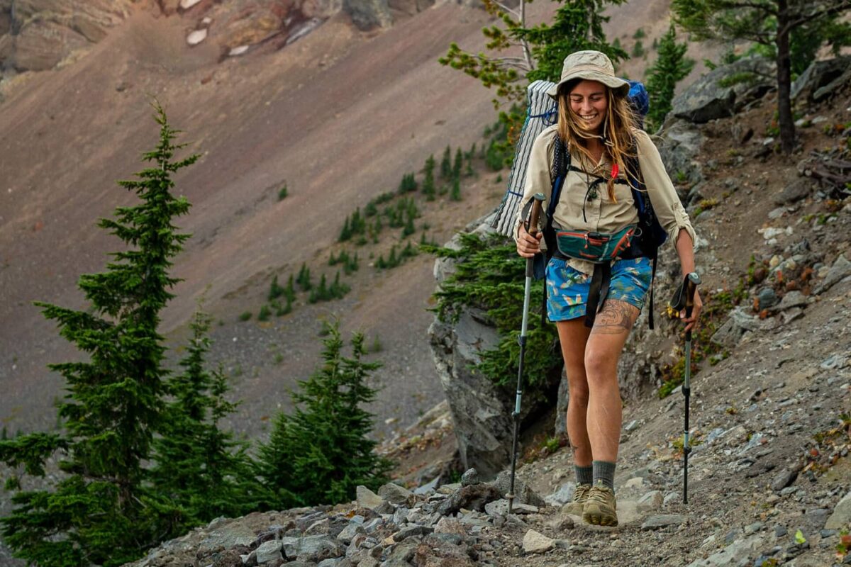 women hiking with big backpack on unpaved trail