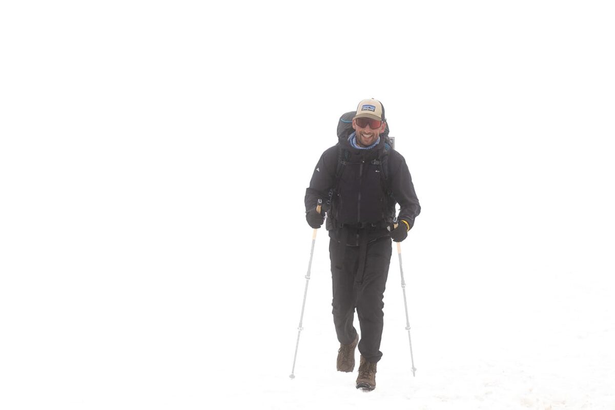 man hiking in the snow with zero visibility