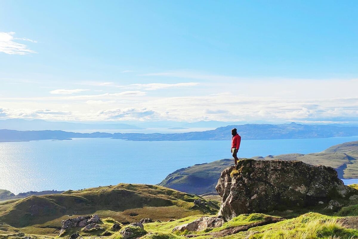 man standing on rock looking out over body of water