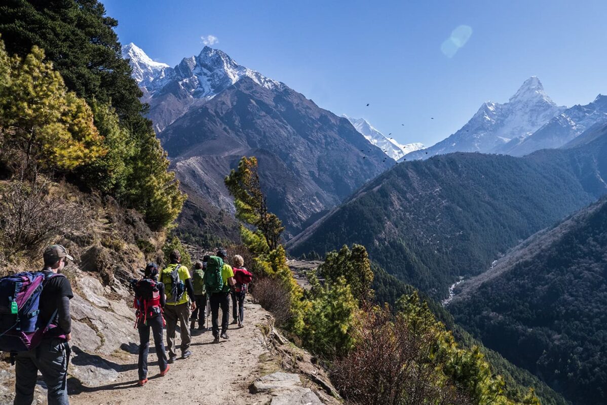 group of people hiking towards mountain top