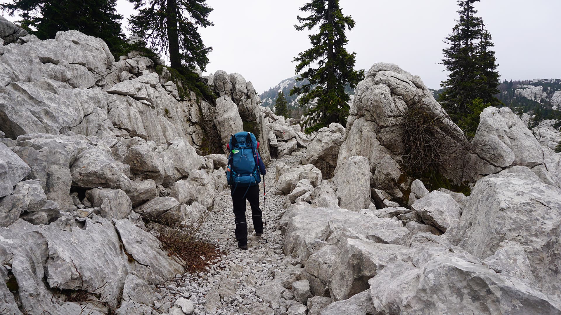 Person hiking between big white boulders