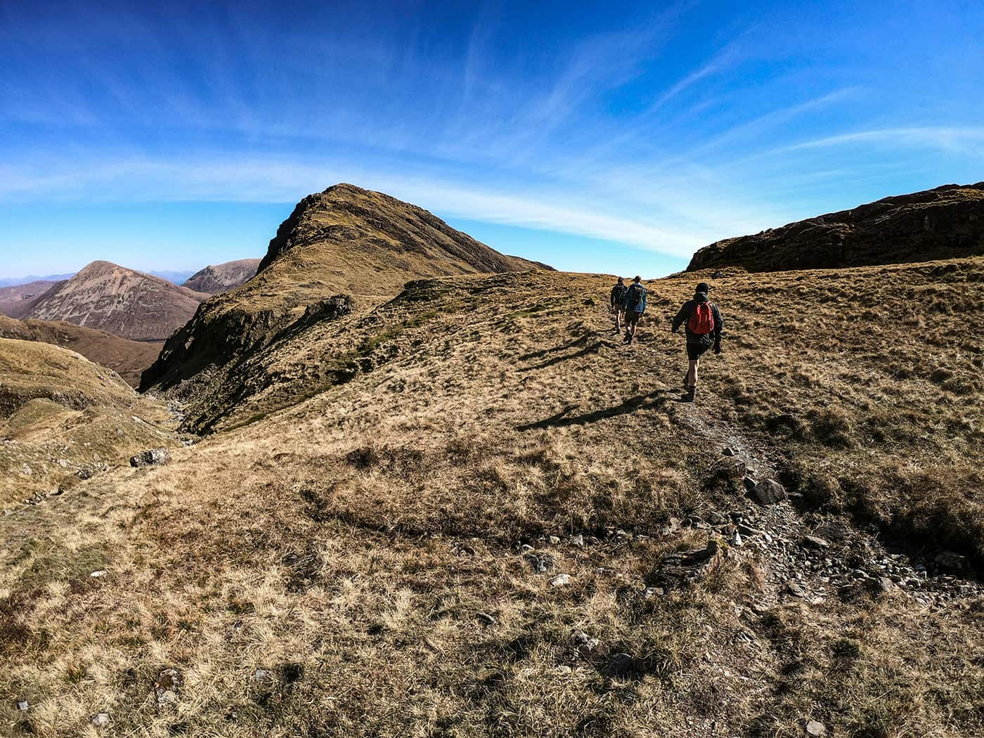 three persons hiking in Scottish highlands