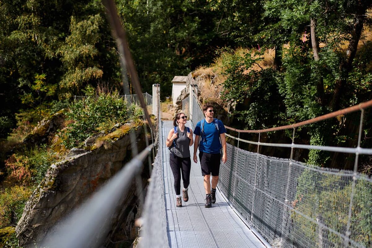 two persons on suspension bridge over valley