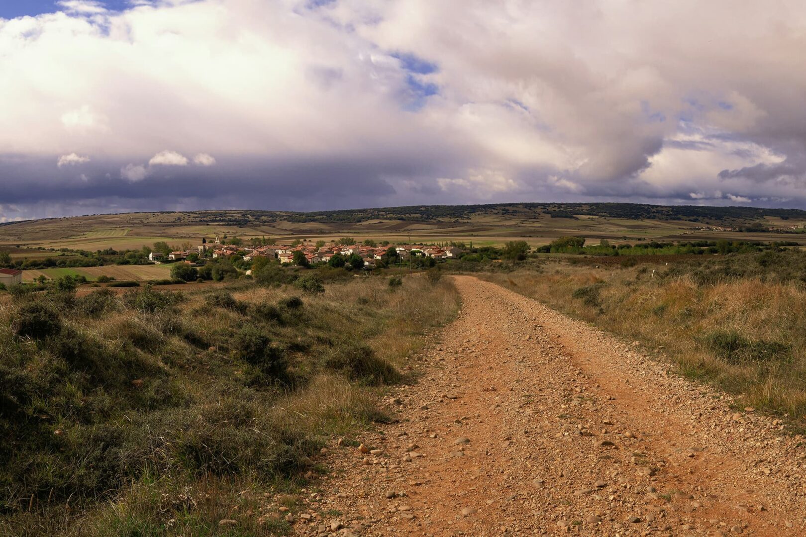 gravel road leading up to small town