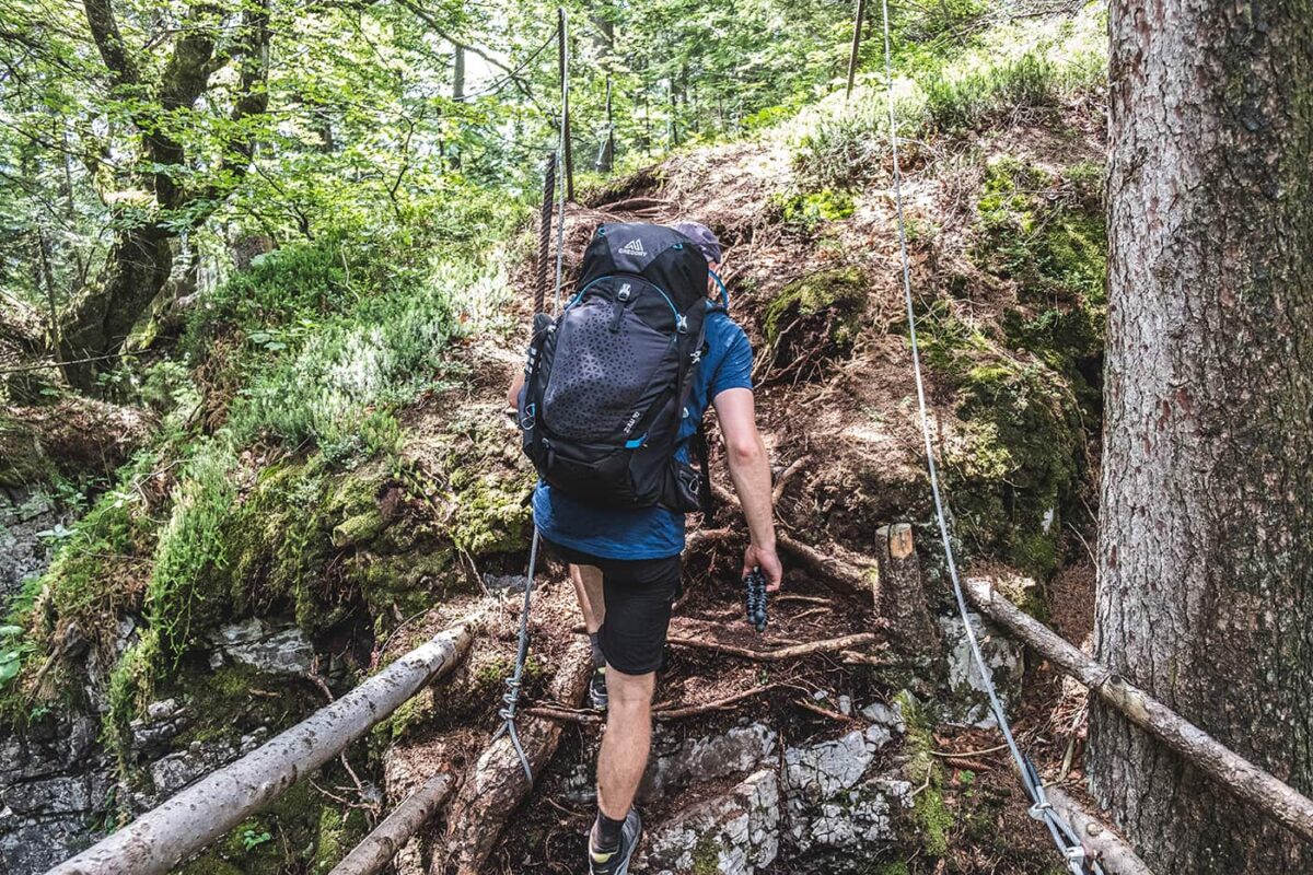 man hiking up path in forest
