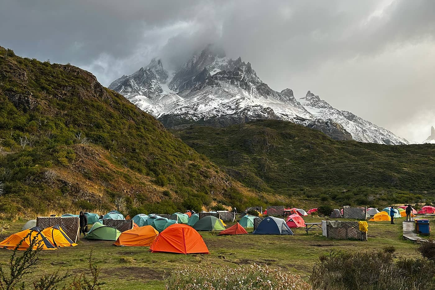 tents on campsite with snowy mountains in background