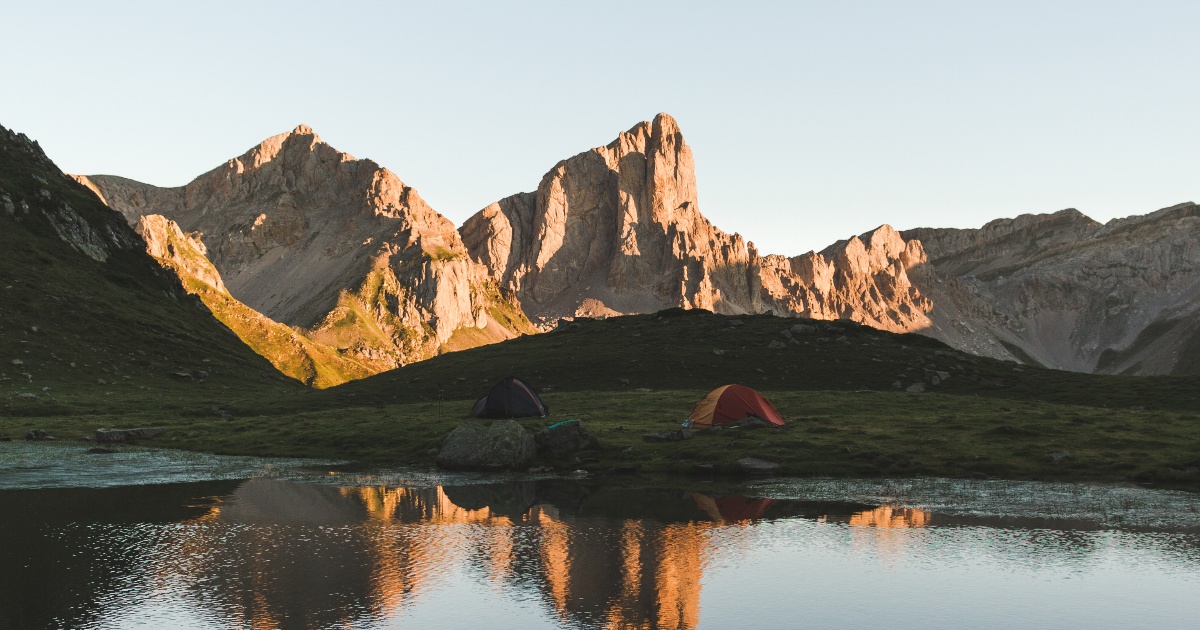 HexaTrek peaks at dawn with tents by a lake