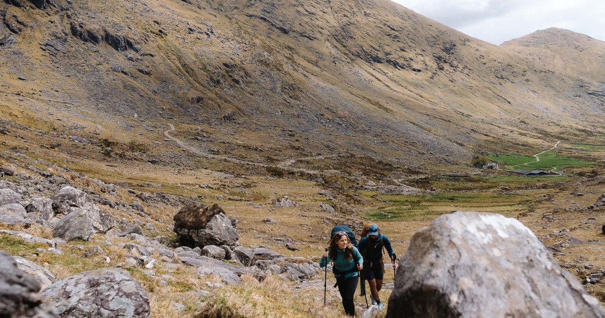 Two people walking in a boulder field in Kerry Way