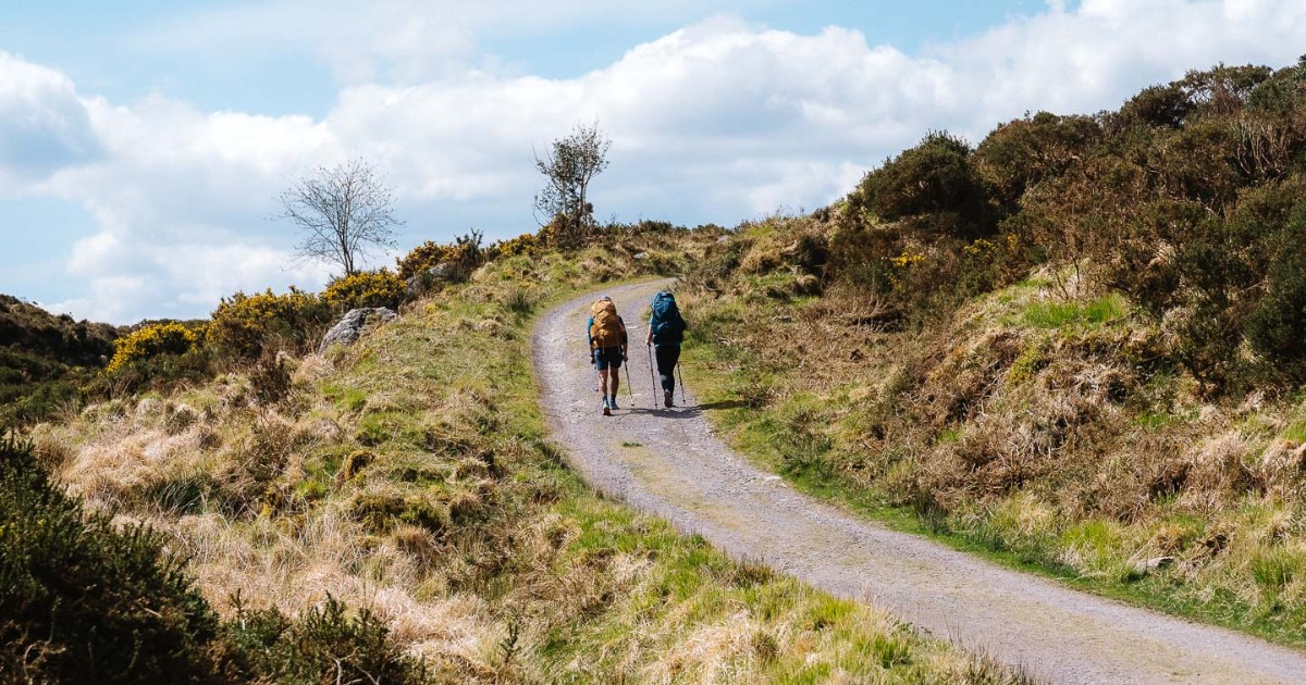 Two people walking on a gravel path on the Kerry Way