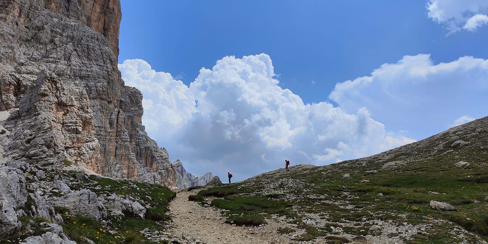 two people hiking on unpaved mountain trail on the Alta Via 1