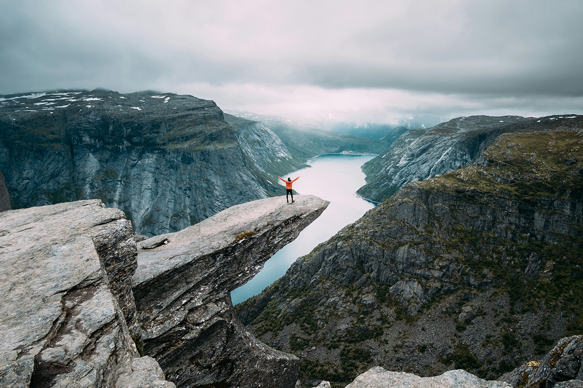 person standing on Trolltunga rock, Norway