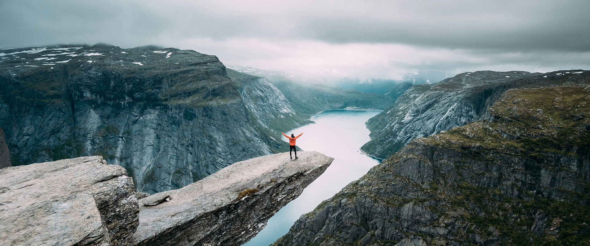 person standing on Trolltunga rock, Norway