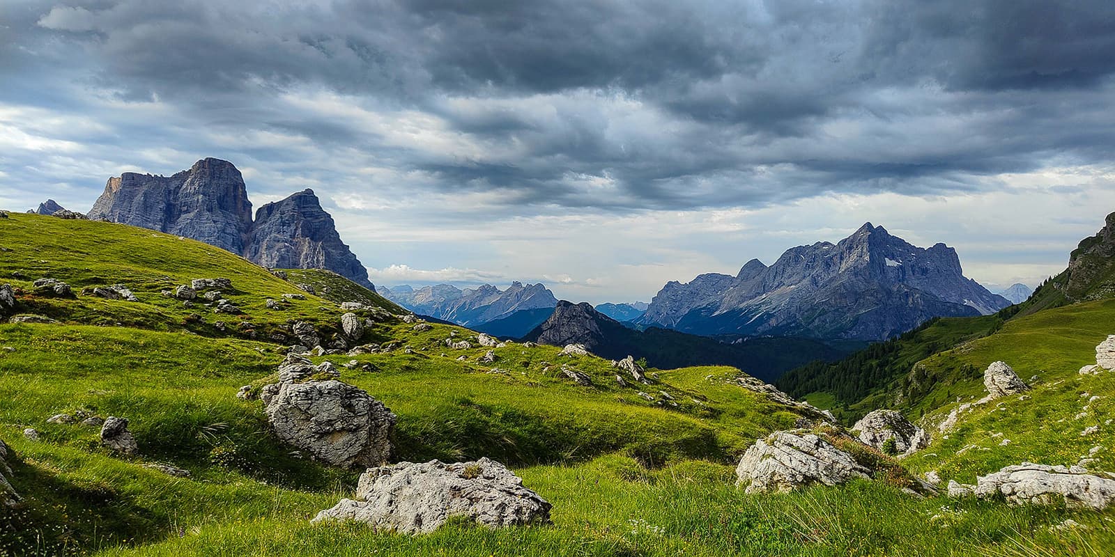 green landscape and rugged mountain peaks on the Alta Via 1 in the Dolomites